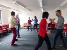 Sechs Personen paarweise bei Übungen in der Bewegten Pause